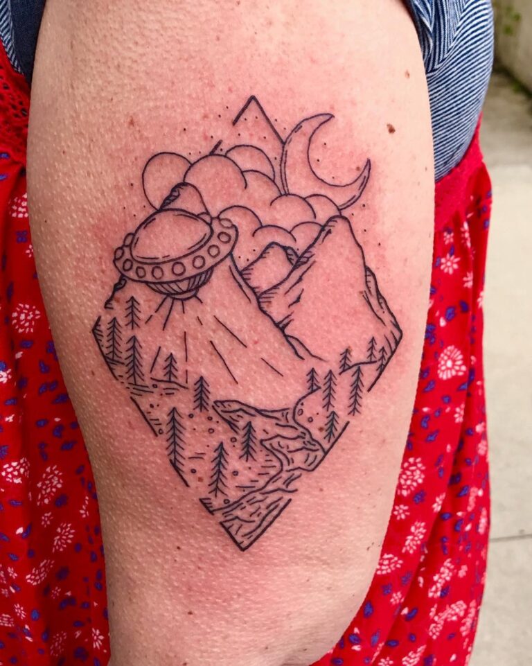 A detailed line art tattoo featuring mountains, a UFO, clouds, and a crescent moon on a person's arm.
