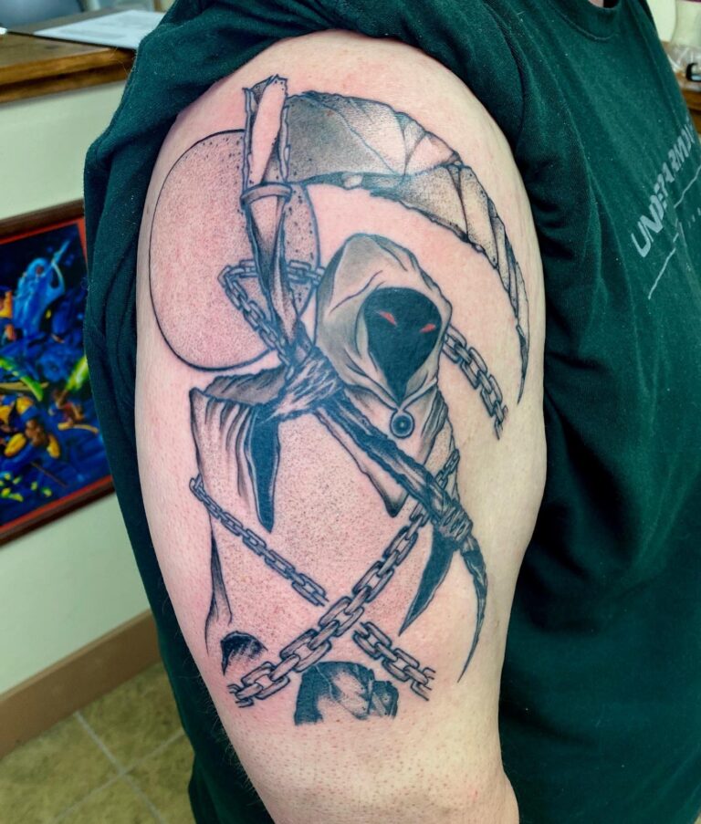 A detailed tattoo of a hooded figure wielding a scythe, surrounded by chains and a crescent moon on a person's arm.