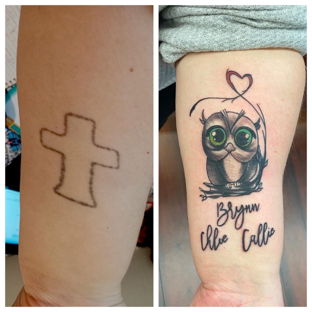 A faded cross tattoo on the left contrasts with a colorful owl tattoo and names on the right arm.