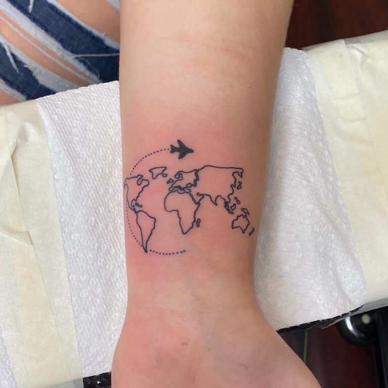 A minimalist tattoo of a world map with an airplane flying above it, symbolizing travel and exploration.