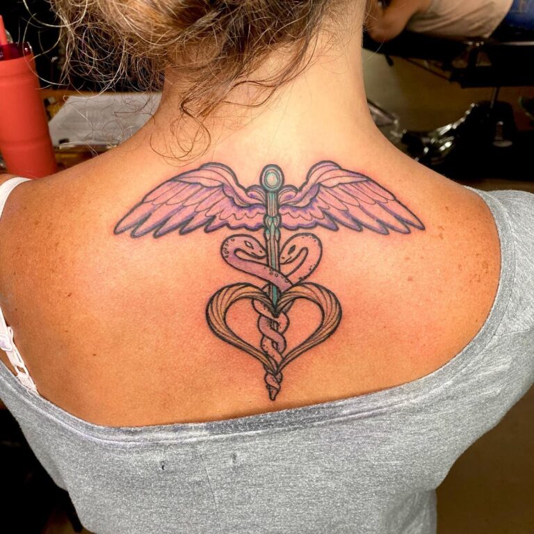A colorful tattoo featuring a winged sword entwined with a heart, located on the upper back.