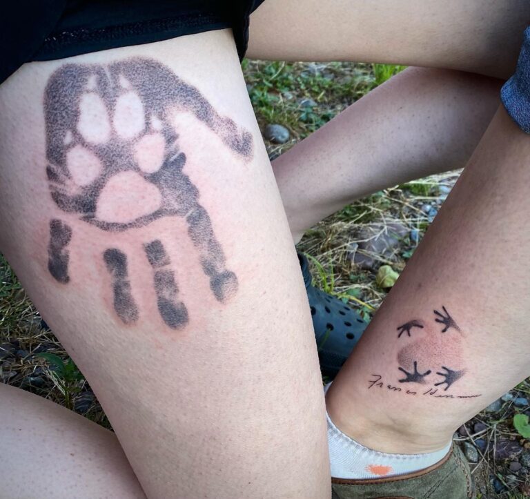 Two legs with tattoos: a handprint and animal tracks, symbolizing connection to nature and personal expression.