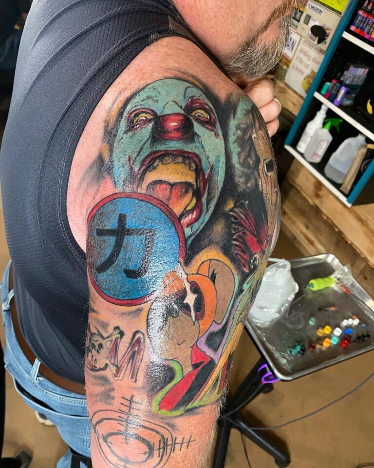 Vibrant tattoo sleeve featuring a colorful clown, skulls, and various designs on a man's arm.