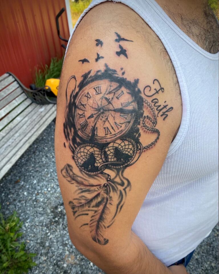 Tattoo on an arm featuring a clock, feathers, dreamcatchers, birds, and the word "Faith.